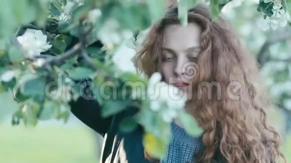 年轻的红发女孩在春天的花朵视频的预览图