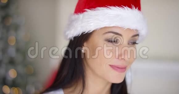 可爱的年轻女子戴着红色圣诞帽视频的预览图
