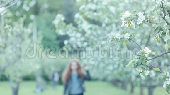 年轻的红发女孩在春天的花朵视频的预览图