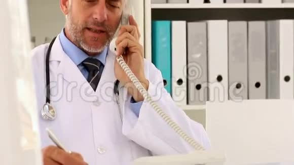 医生在办公桌上打电话视频的预览图