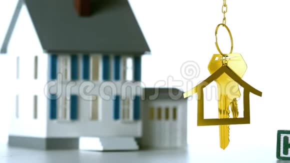 房子钥匙和钥匙挂在3d房子模型的背景上视频的预览图