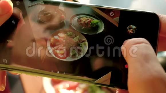 女孩在一家咖啡馆里用智能手机拍了一张吃饭的照片视频的预览图