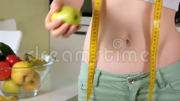 苗条的女人在一盘水果和蔬菜的背景下保持着健康的生活方式视频的预览图