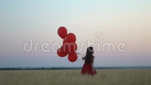 太阳落山时有气球在麦田里奔跑的快乐女孩视频的预览图