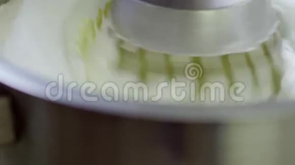 电动搅拌器将奶油倒入金属碗中视频的预览图
