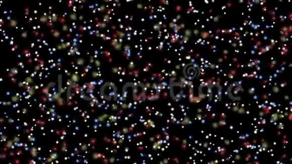 五彩光粒子在黑色背景上缓慢不均匀运动用于庆祝的视频背景视频的预览图