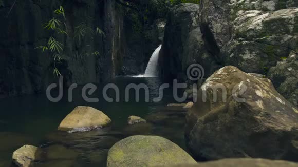 雨林中的山瀑布瀑布流出来的水流在河中的大石头上视频的预览图