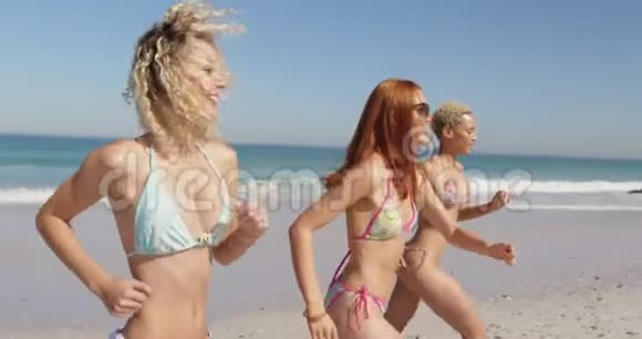 在海滩跑步的年轻成年女性朋友视频的预览图