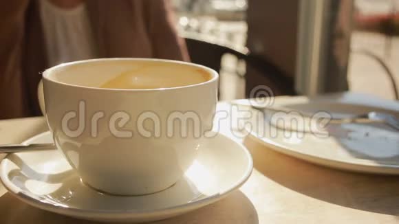 女人把慕斯从咖啡里调出来吃关上杯子视频的预览图