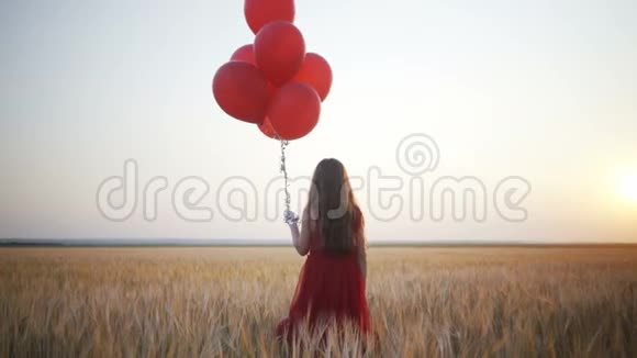 太阳落山时带着气球在麦田里奔跑的快乐少女视频的预览图