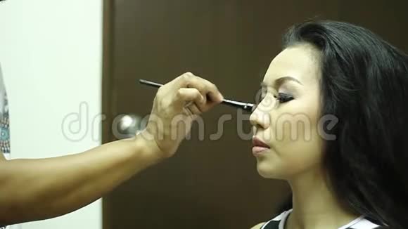 化妆师给一个年轻女人做眼影视频的预览图