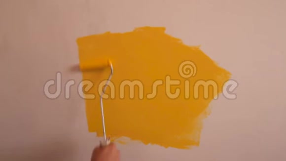 建筑工人和专业油漆工使用油漆滚筒刷油漆墙壁黄色视频的预览图