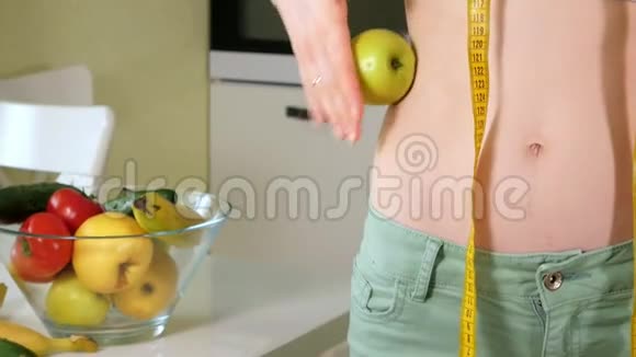 苗条的女人在一盘水果和蔬菜的背景下保持着健康的生活方式视频的预览图