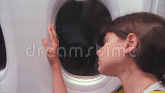 航空飞机概念年轻女孩看着坐在窗边的飞机晚上乘飞机飞行视频的预览图