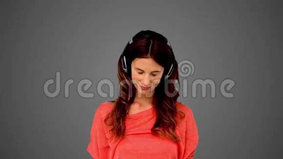 在灰色背景下听音乐的女人视频的预览图