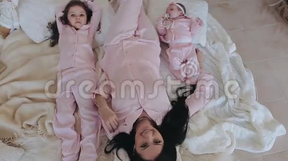 母亲和女儿穿着粉红色睡衣的新生婴儿在平安夜视频的预览图