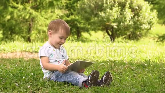 快乐男孩在户外玩平板电脑慢动作视频的预览图
