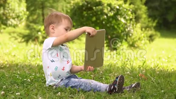 在公园里用平板电脑的男孩慢动作视频的预览图