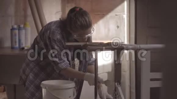 女孩木匠设计师装饰师在一个修复旧家具的车间工作视频的预览图