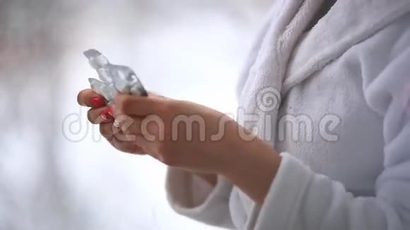 女人手里拿着药片药片和玻璃杯视频的预览图