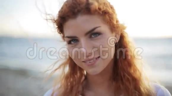 快乐的年轻红发女人在海滩上的脸视频的预览图