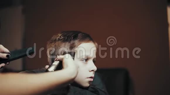 给男孩剪剪头发在理发师梳头视频的预览图