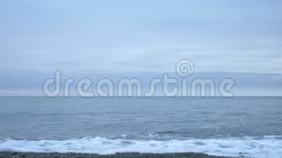 日落时的卵石海滩波浪飞溅碎成飞沫4k慢动作视频的预览图