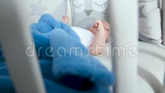 新生儿躺在白色的圆床上有移动设备视频的预览图