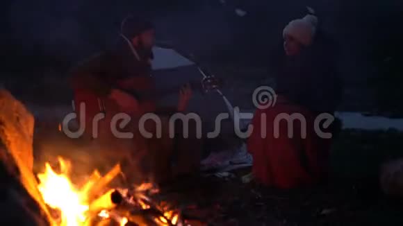 几个黄昏时分在篝火旁的旅行者视频的预览图
