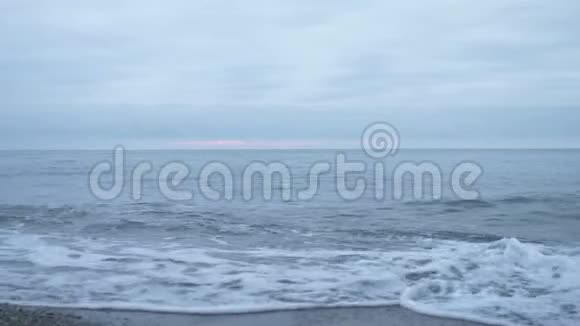 日落时的卵石海滩波浪飞溅碎成飞沫4k慢动作视频的预览图