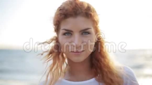 快乐的年轻红发女人在海滩上的脸视频的预览图