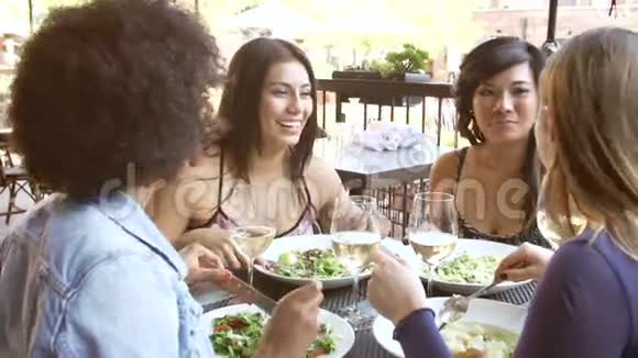 在户外餐厅享用美食的女性朋友小组视频的预览图