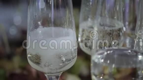 服务员把香槟倒进玻璃杯里桌上摆满了一杯含瓶子的起泡白葡萄酒视频的预览图