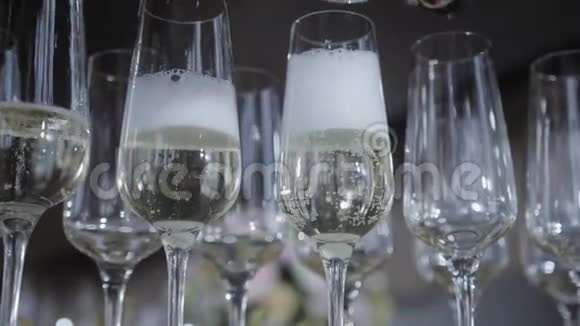 服务员把香槟倒进玻璃杯里桌上摆满了一杯含瓶子的起泡白葡萄酒视频的预览图