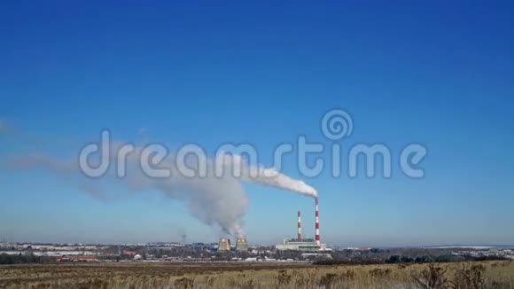 火力发电厂或有吸烟烟囱的工厂污染烟雾进入晴朗的蓝天视频的预览图