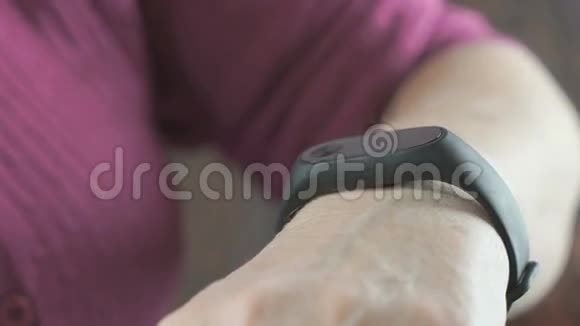 老年妇女使用智能健身追踪器视频的预览图