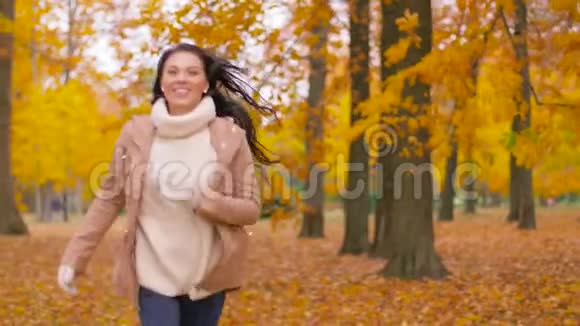 秋天公园里快乐的年轻女子奔跑视频的预览图