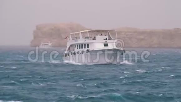 欢乐的船与游客航行在风暴海的背景岩石埃及视频的预览图