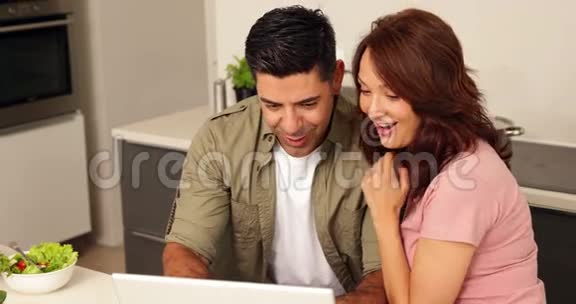 年轻夫妇聊天看着笔记本电脑视频的预览图