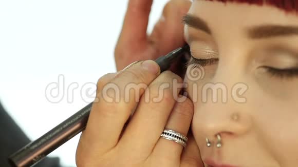 专业化妆师日常化妆的特写用刷子把粉涂在女人的脸颊上视频的预览图
