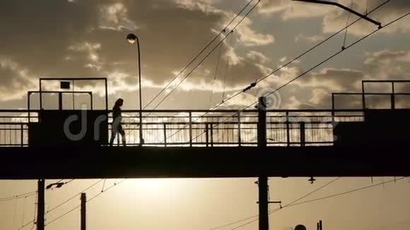 旧钢桥上穿越铁路的人群剪影视频的预览图
