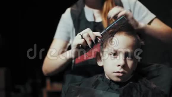 给男孩剪剪头发在理发师梳头视频的预览图