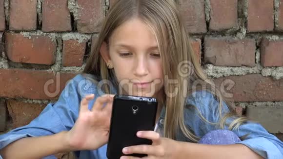 儿童使用智能手机儿童玩智能手机儿童户外公园视频的预览图