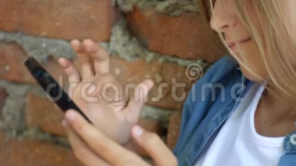 儿童使用智能手机儿童玩智能手机儿童户外公园视频的预览图