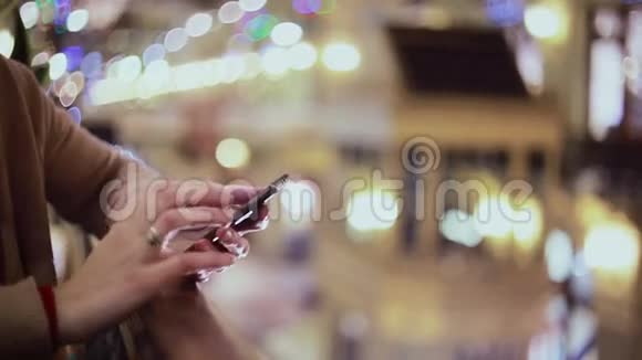 女人手发短信在商场里用智能手机视频的预览图
