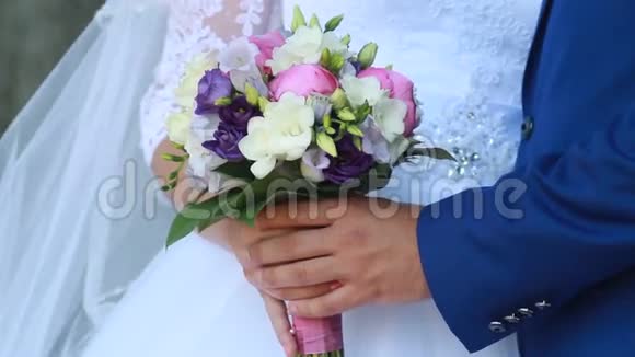 手和戒指在婚礼花束上视频的预览图