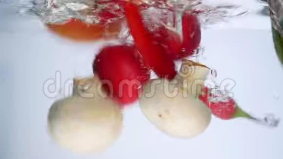 混合蔬菜在水中搅拌辣椒西红柿黄瓜和萝卜视频的预览图