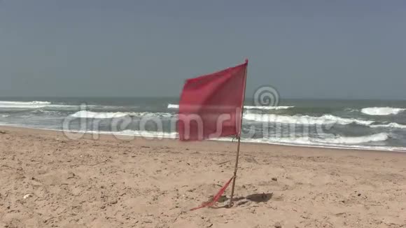 在荒无人烟的海滩上飘扬的红色警示旗视频的预览图