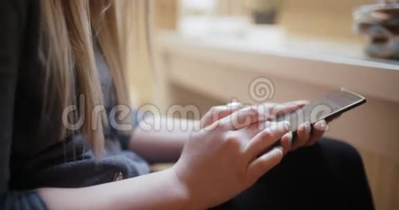 家里的女人用智能手机视频的预览图