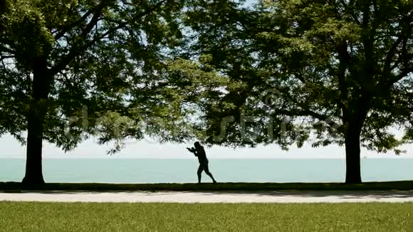 青年运动员积极从事运动跨体拳击跆拳道的湖岸慢动作视频的预览图